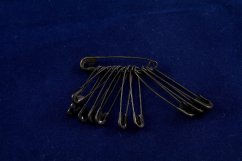 A mixture of small black safety pins
