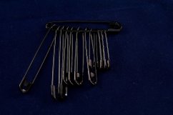 A mixture of large black safety pins
