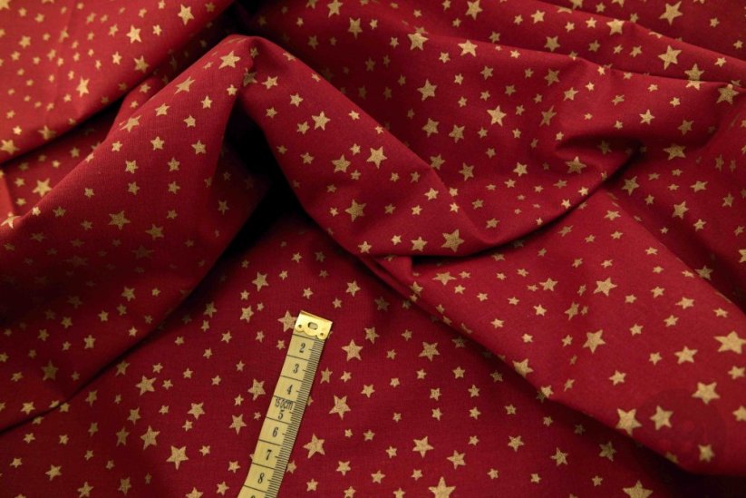 Cotton canvas - gold metallic stars on a dark red background - width 150 cm